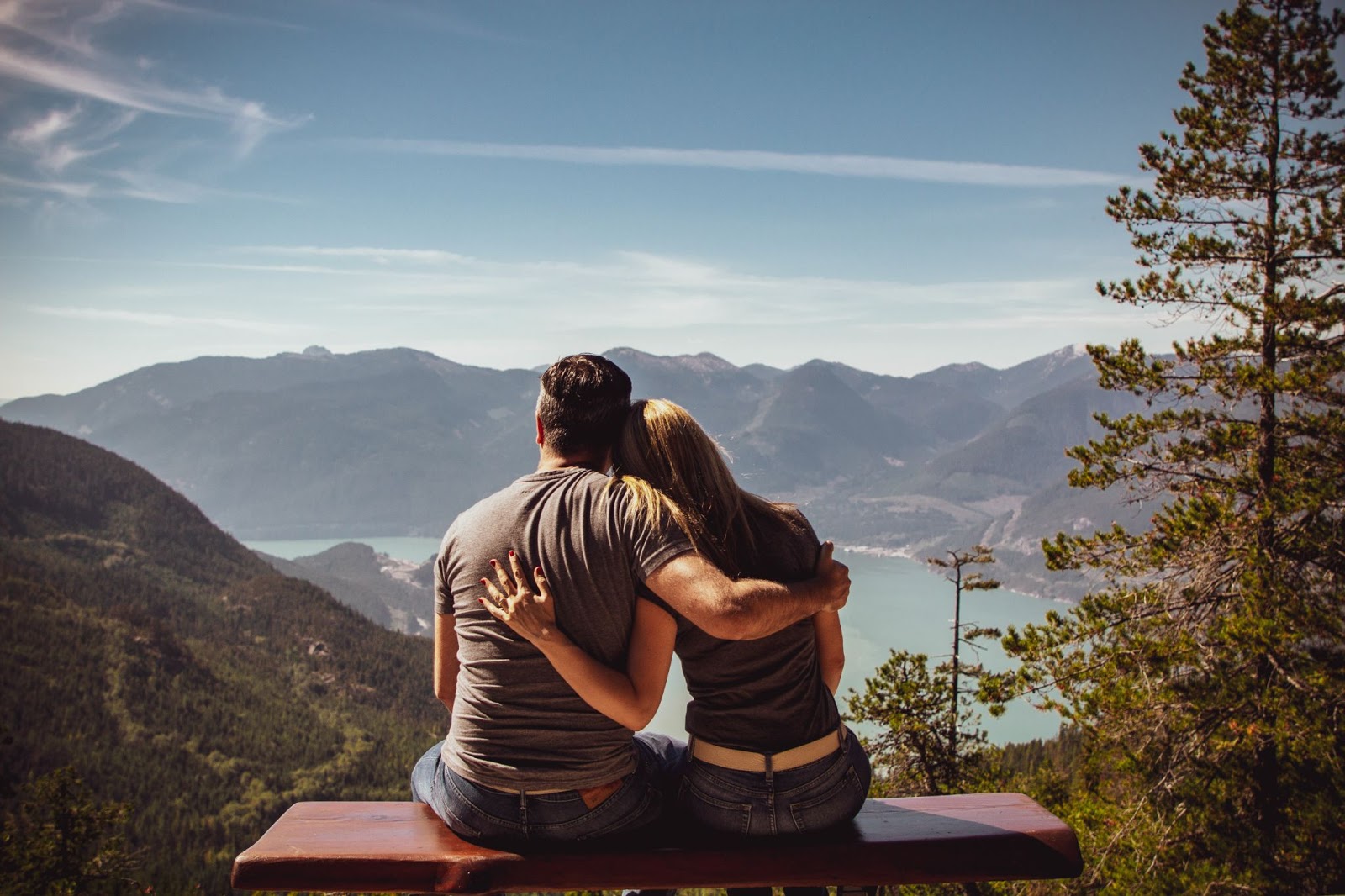 Man and Woman Sitting on Bench Viewing a Mountain Range